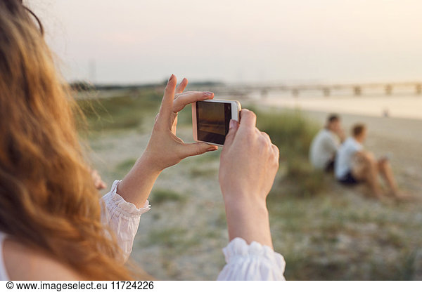 Young woman taking photo on beach