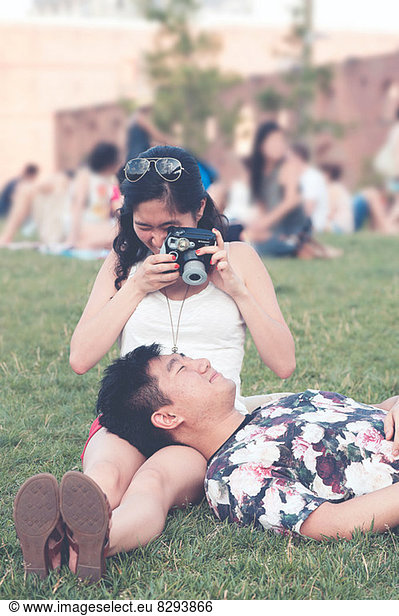 Young woman taking photograph of boyfriend