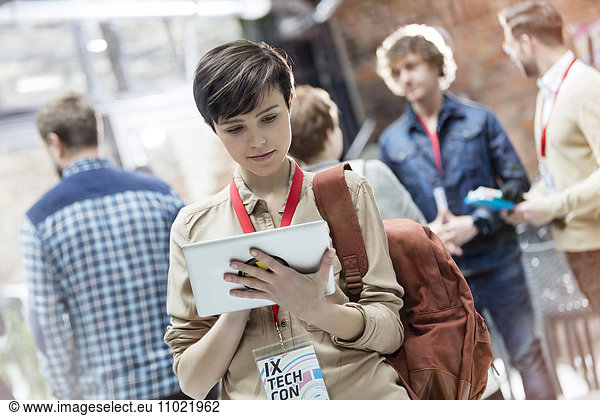 Young woman using digital tablet at technology conference
