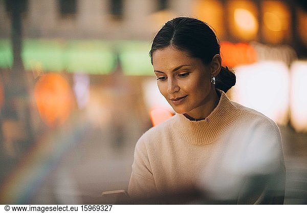 Young woman using phone in city