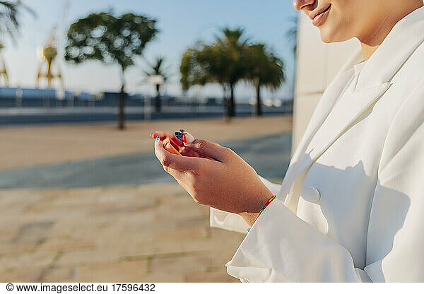 Young woman using smart phone on sunny day