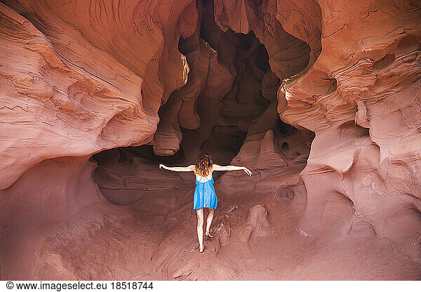 Young woman walking in red sand cave