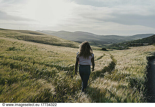 Young woman walking on meadow