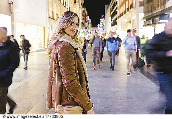 Young woman walking on street in city