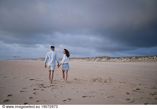 Young woman walking with boyfriend at beach