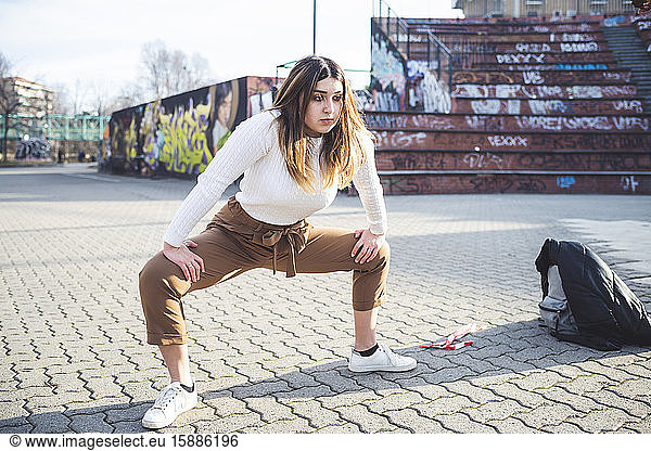 Young woman warming up in a skate park
