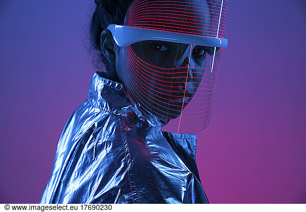 Young woman wearing smart glasses against multi-colored background