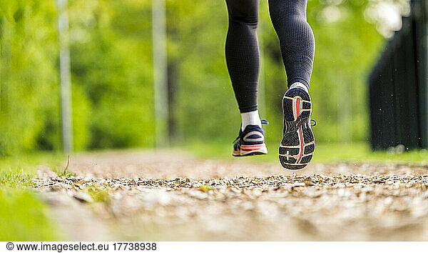Young woman wearing sport shoes jogging in park