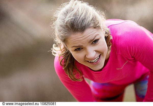 Young woman wearing sportswear bending over exhausted