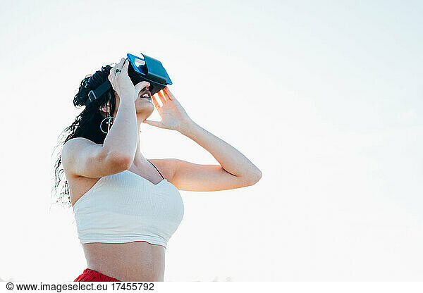Young woman wearing VR goggles in a coastal area