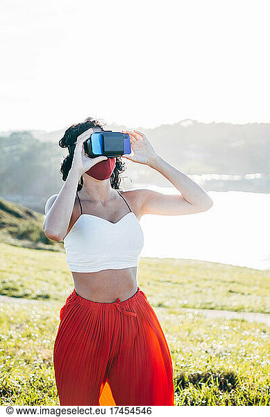 Young woman wearing VR goggles wearing facial mask