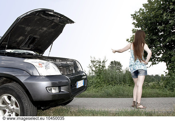 Young woman with a broken down car