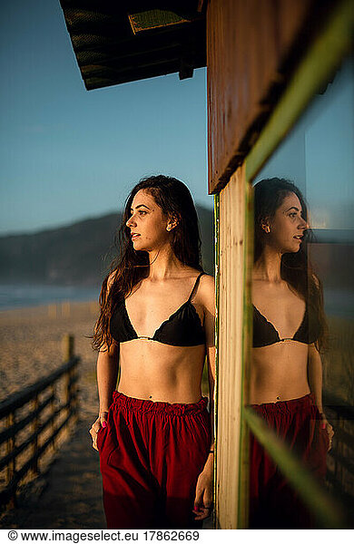 Young woman with bikini looking at horizon at the beach