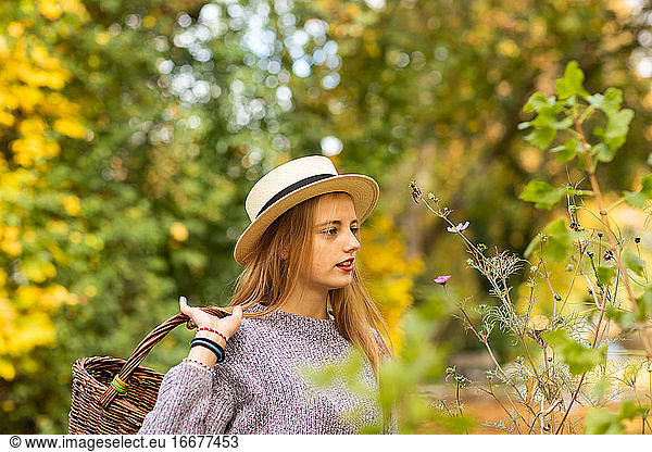 young woman with blond hair and hat in an urbanic garden