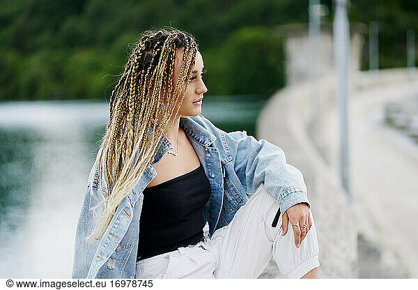 Young woman with blonde braided hair wearing a denim jacket and
