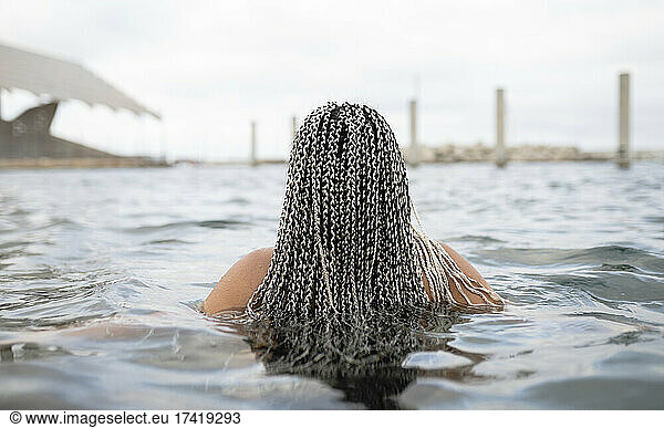 Young woman with braided hair in water during weekend