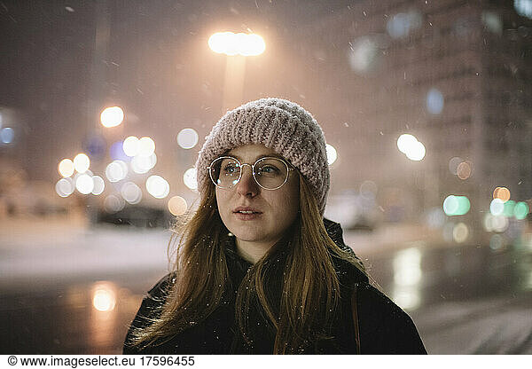 Young woman with brown hair on street in winter at night