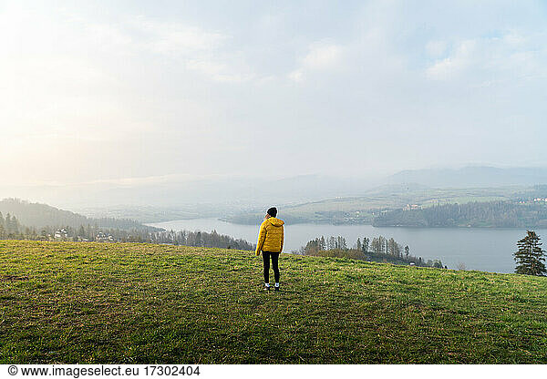 Young woman with cap  and yellow coat  at the top of the Falsztyn view