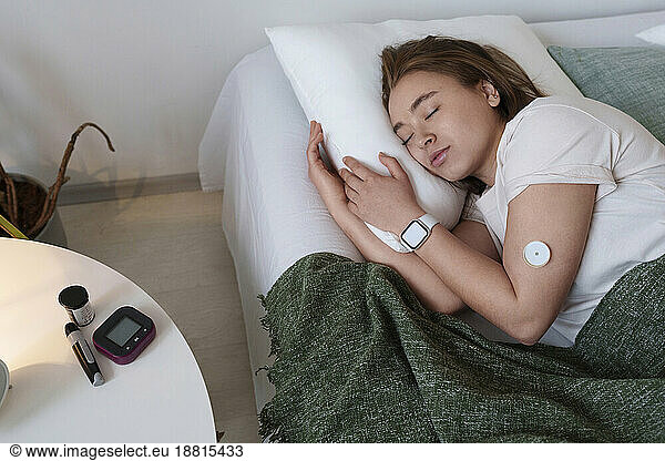 Young woman with diabetes sleeping in bed at home
