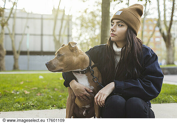 Young woman with dog sitting at park
