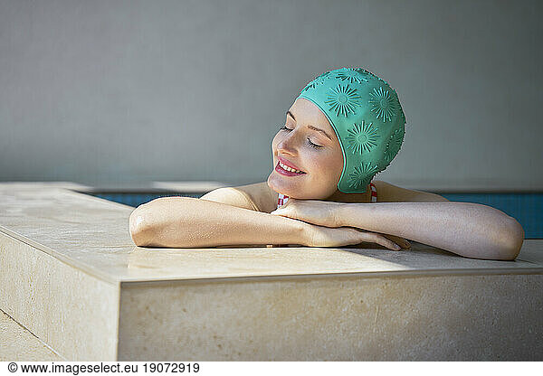 Young woman with eyes closed relaxing in hot tub at spa