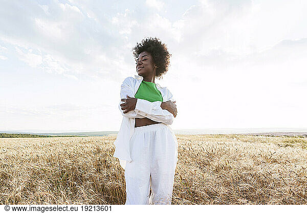 Young woman with eyes closed standing in field