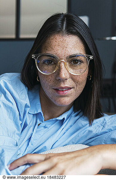 Young woman with freckles on face at home