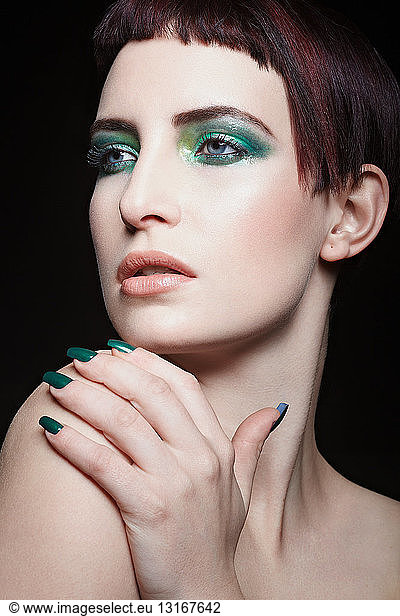 Young woman with green eyeshadow and nail varnish  portrait