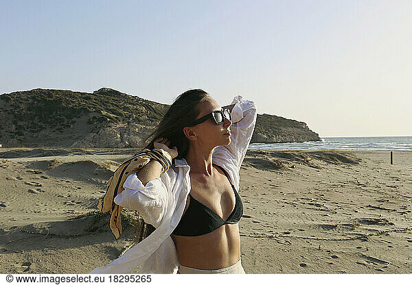 Young woman with hands behind head standing at beach  Patara  Turkiye