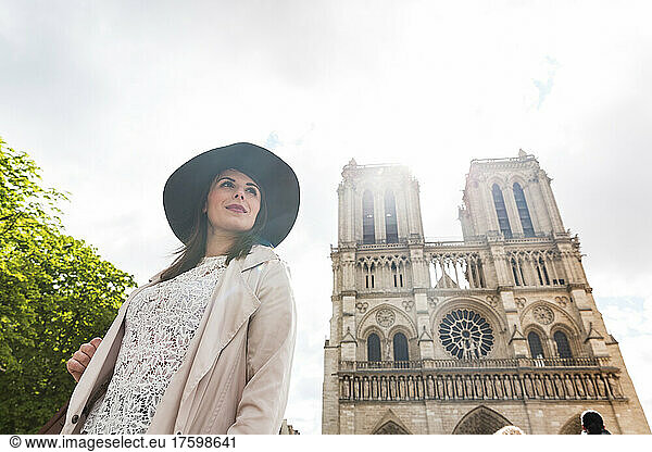 Young woman with hat at Notre Dame Cathedral on vacation