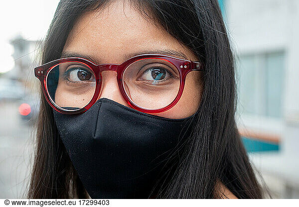 Young woman with red glass and face mask
