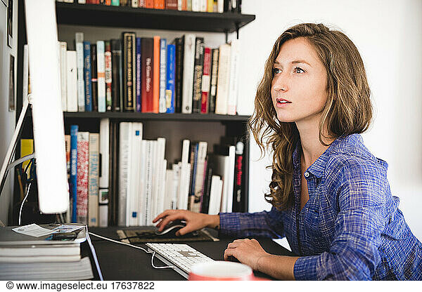 Young woman working on computer at home