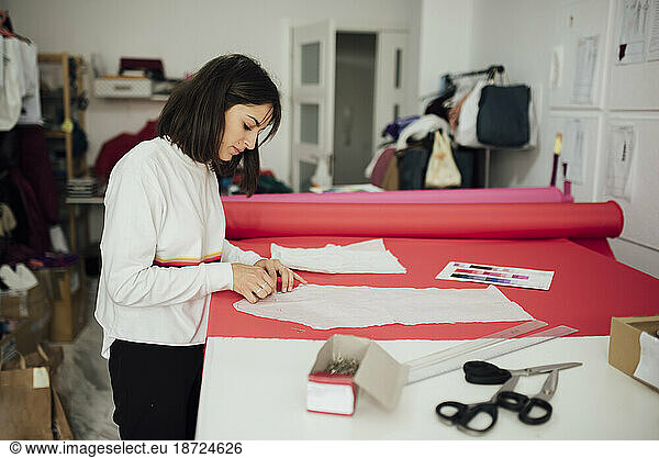 young woman working with a sewing pattern in a fashion design