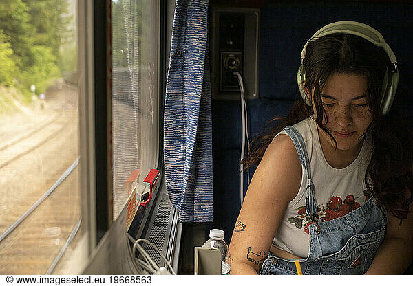Young woman writes on passenger train ride