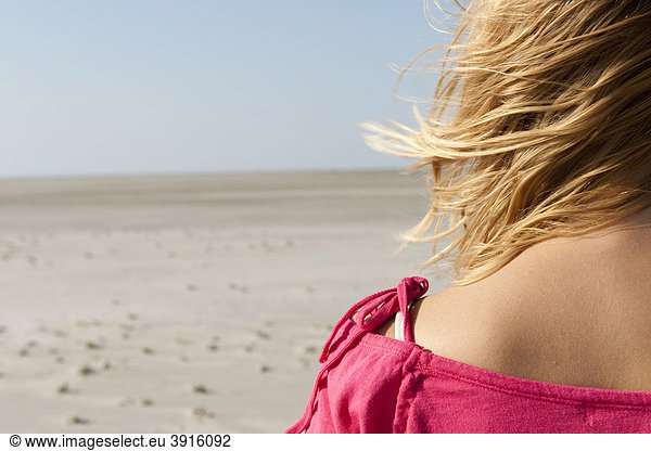 Young woman  20-25 years  on a windy day at the beach in St Peter Ording  North Sea  North Friesland  Schleswig-Holstein  northern Germany  Germany  Europe