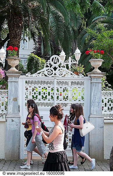 Young women pass the gates of an Ottoman-era wali or summer house on Buyukada  Princes Islands  Istanbul.