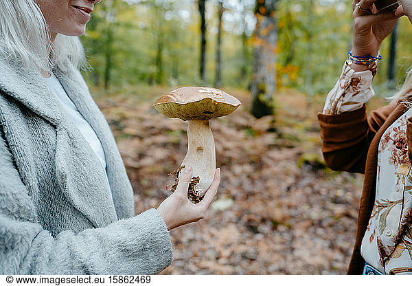 Young Women taking pictures of a giant mushroom in a forest