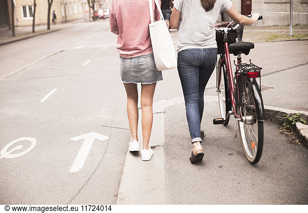 Young women walking with bike