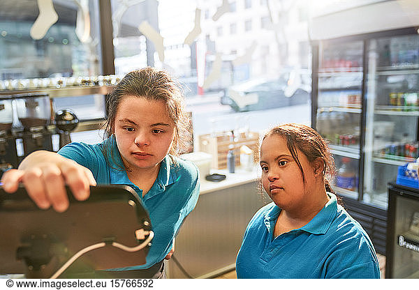Young women with Down Syndrome working in cafe