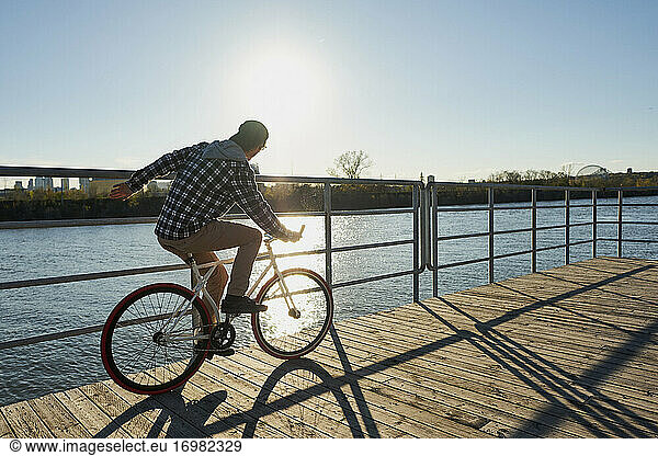 Youthful man on fixed gear bike cycling around city