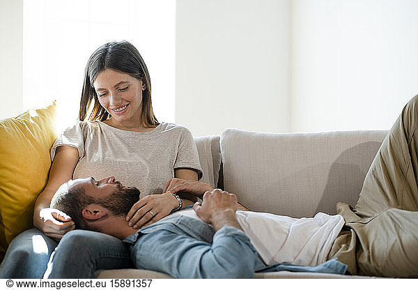 Zärtliches junges verliebtes Paar  das sich zu Hause auf der Couch entspannt