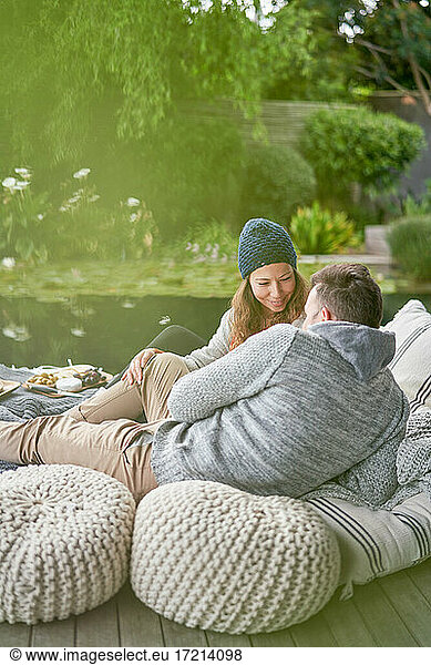 Zärtliches romantisches Paar entspannt sich auf Terrassen-Kissen