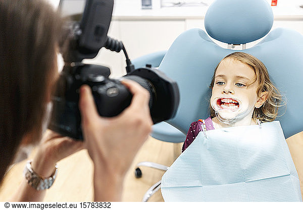 Zahnarzt fotografiert Mädchen in Zahnbehandlung
