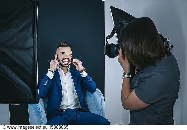 Zahnarzt fotografiert Mann bei Zahnbehandlung