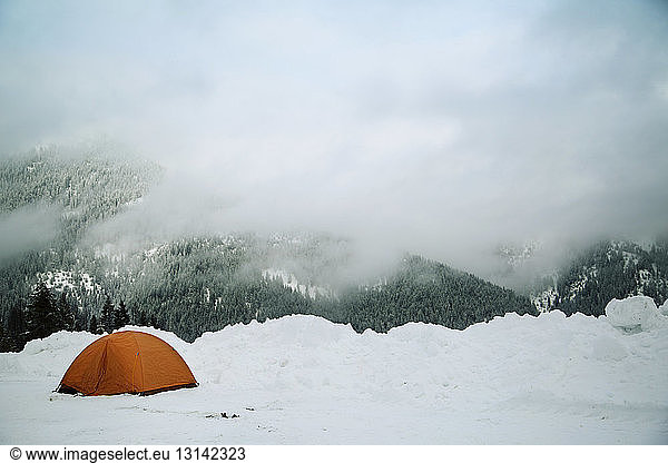 Zelt auf verschneiter Landschaft bei nebligem Wetter