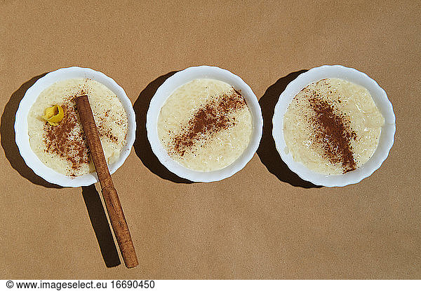 zenithal plane of three rice pudding desserts on a brown background
