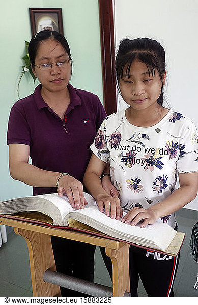Zentrum für blinde Kinder  das von Children Action betrieben wird. Katholische Kapelle. Ein blindes Mädchen liest eine Bibel in Blindenschrift. Ho Chi Minh Stadt. Vietnam.