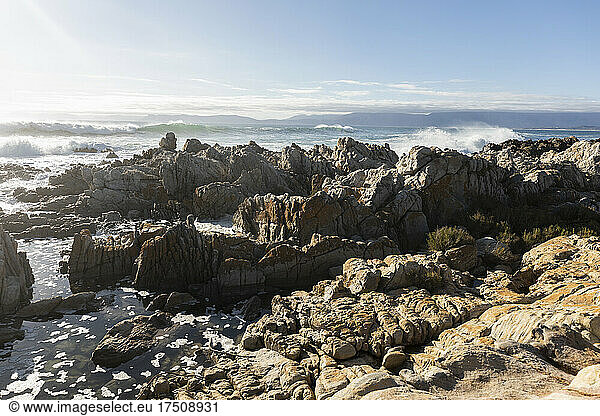Zerklüftete Felsen am Ufer von De Kelders  hohe Wellen rollen heran und brechen sich an den Felsen