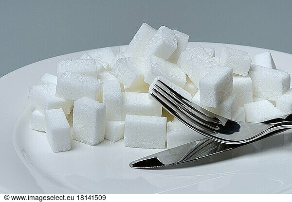 Zuckerwürfel auf Teller mit Besteck  Zuckerkonsum  Zuckerverbrauch