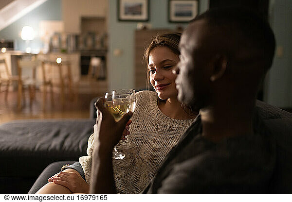 Zufriedene Frau genießt Wein mit afroamerikanischem Freund